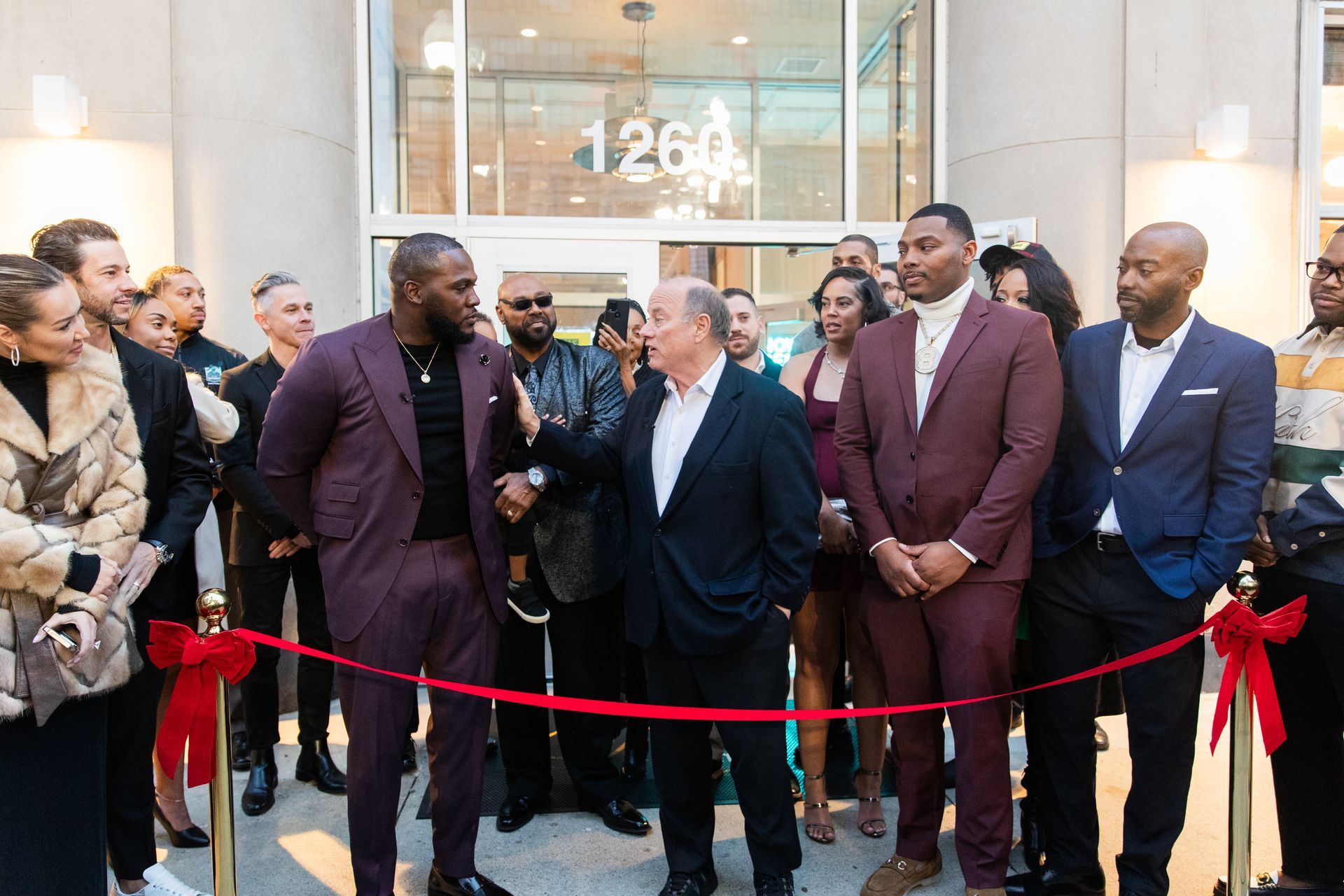 A group of people standing in front of a building with the number 1264 on it
