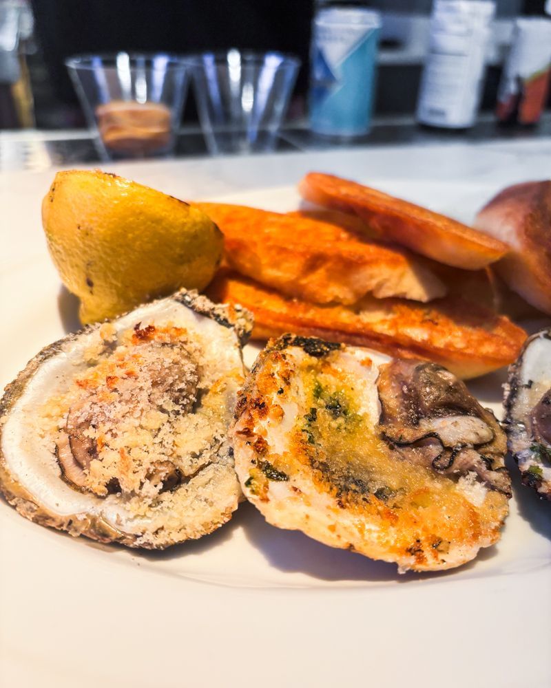 A white plate topped with oysters and french fries