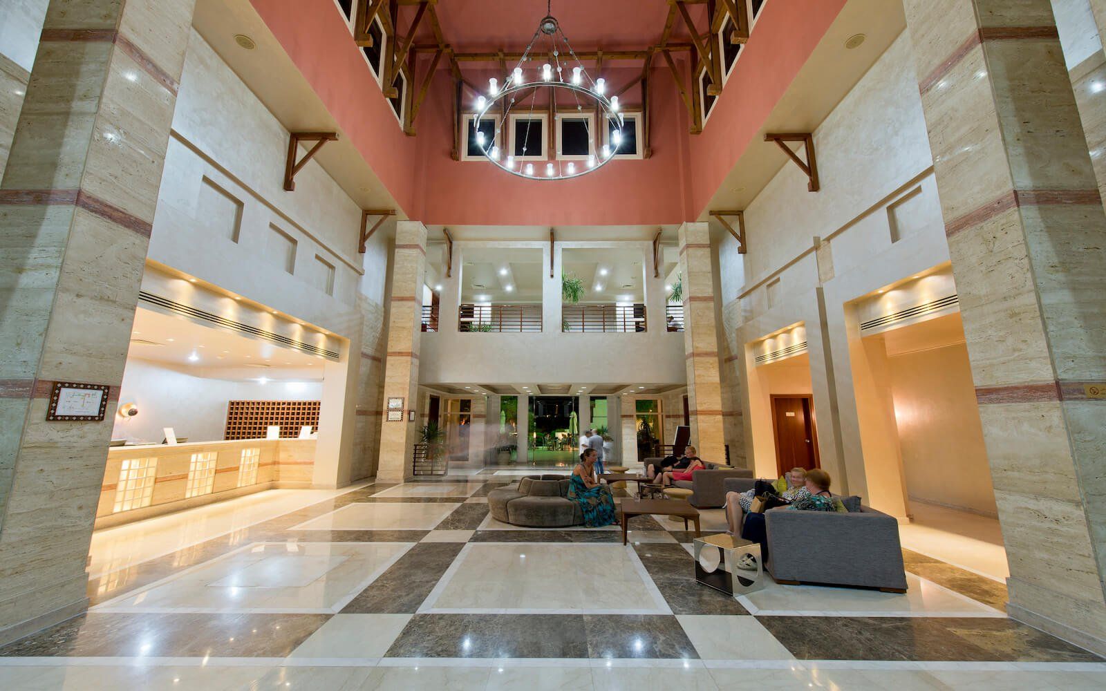 Luxurious hotel entrance with high ceilings and cozy lounge area for guests.