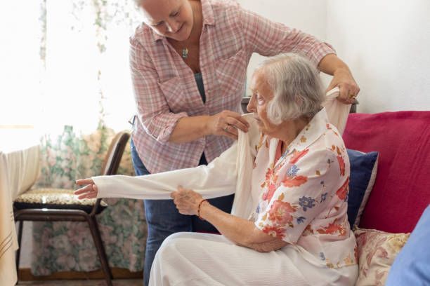 A doctor and a nurse are talking to an old man lying in a bed