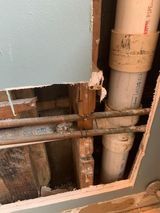 a hole in the wall with pipes coming out of it .