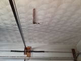 a close up of a garage door with a hole in the ceiling .
