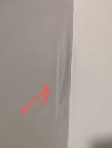 a red arrow is pointing to a hole in the wall .