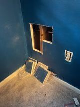 there is a hole in the wall in the corner of the room .