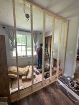a man is standing in a room surrounded by wooden frames .