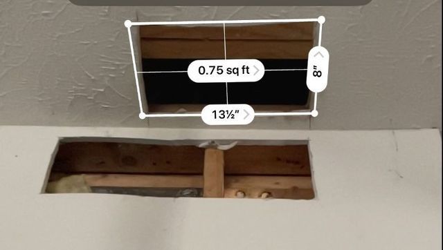 a picture of a hole in the ceiling being measured .