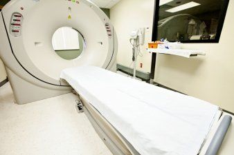 A hospital room with a ct scan machine and a bed