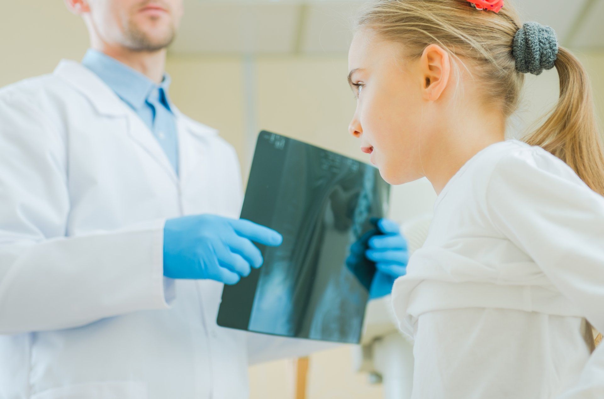 A little girl is looking at an x-ray with a doctor.