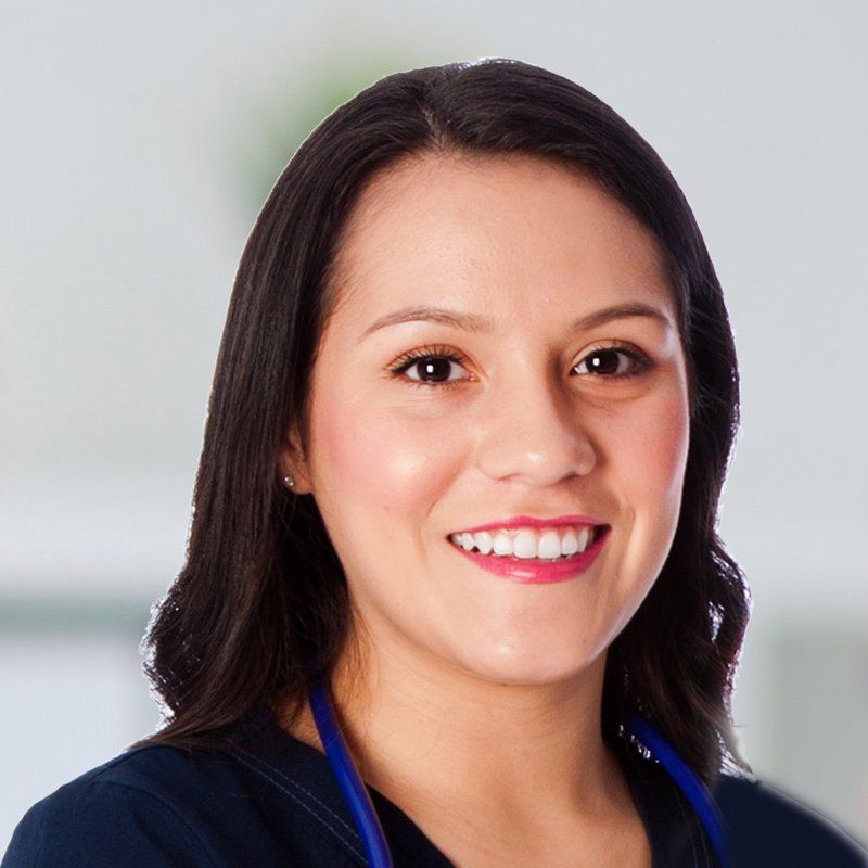 A woman wearing a stethoscope around her neck is smiling for the camera.