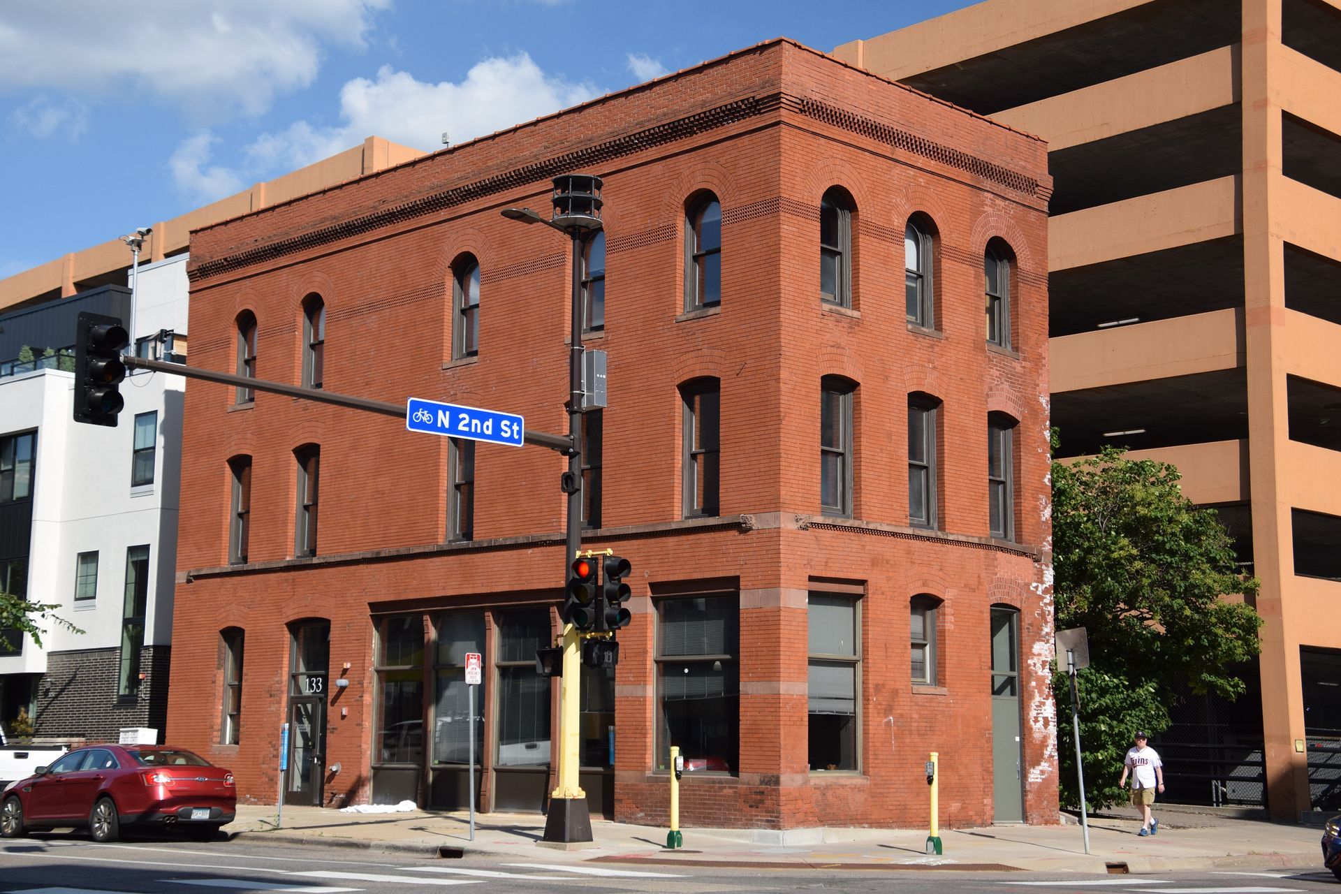 Red brick building at a street corner with street sign.