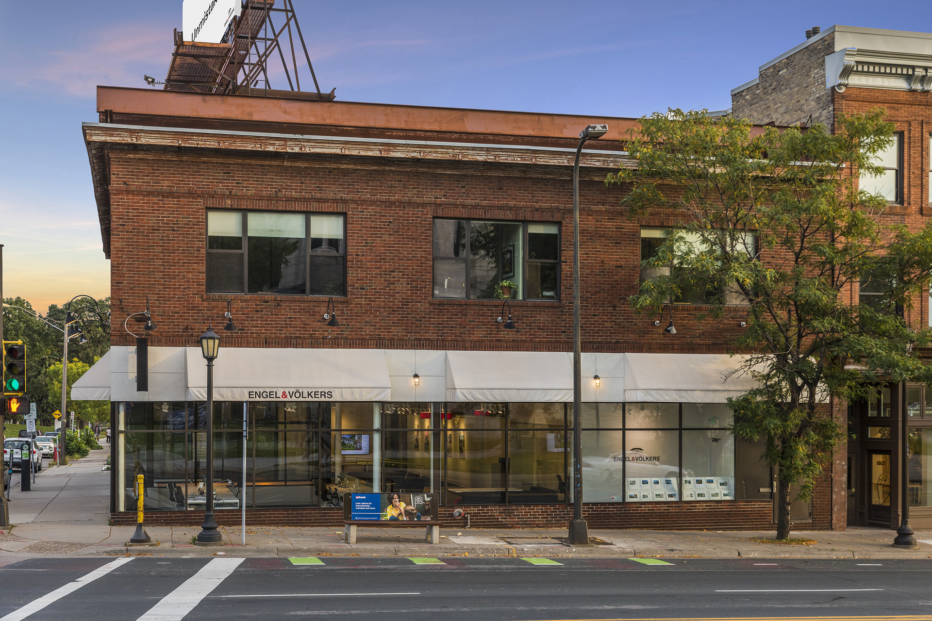 A two-story brick building with a modern storefront on a city street.