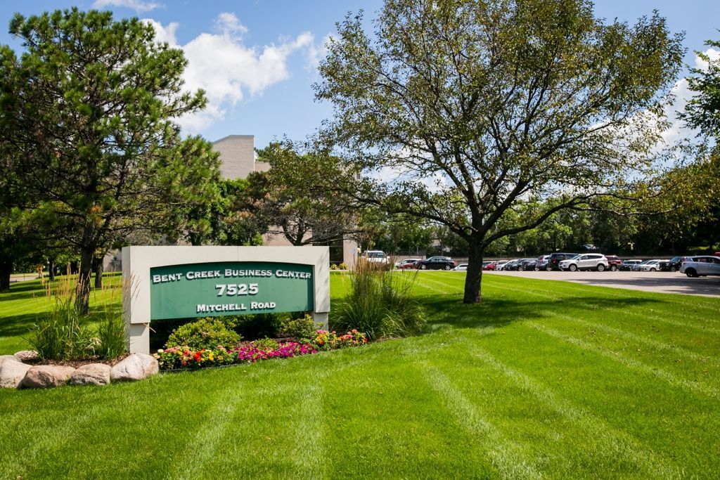 Sign for Bent Creek Office Center, with green lawn, trees, and blue sky.