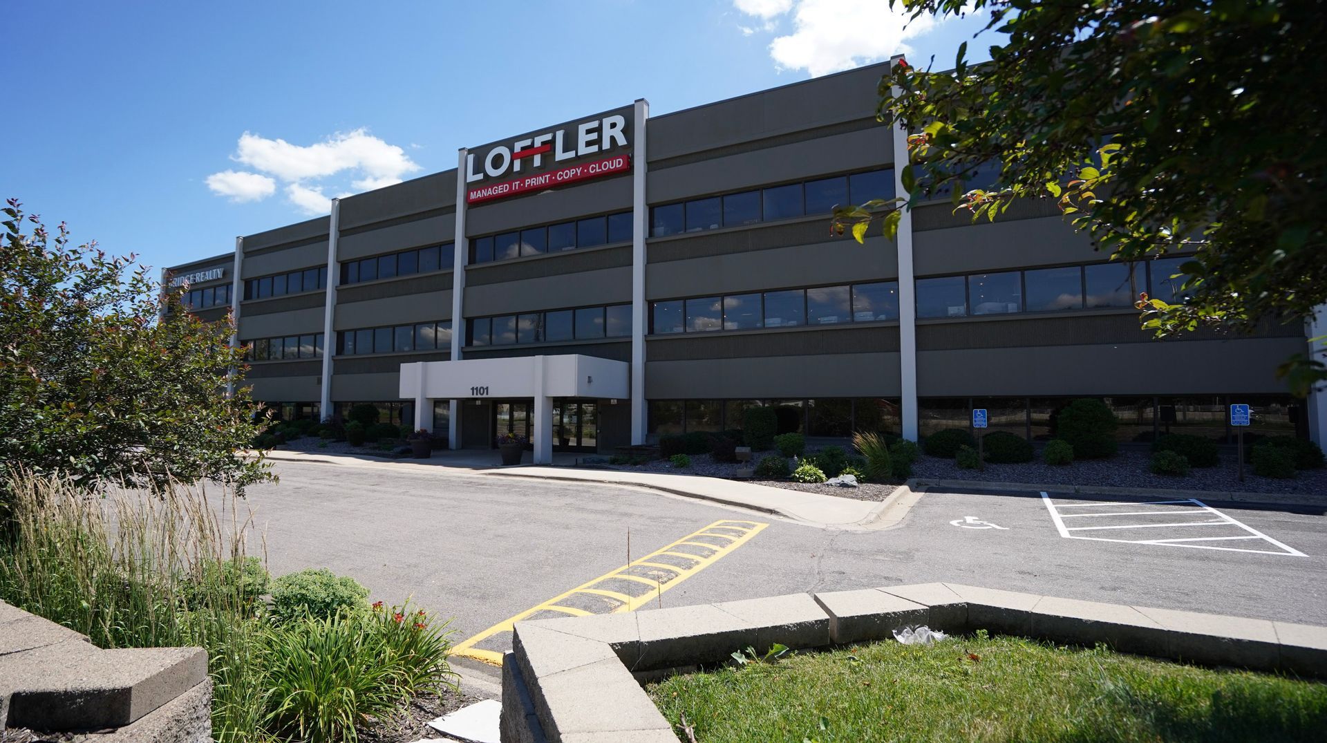 Three-story building, gray exterior, three stories, blue sky.