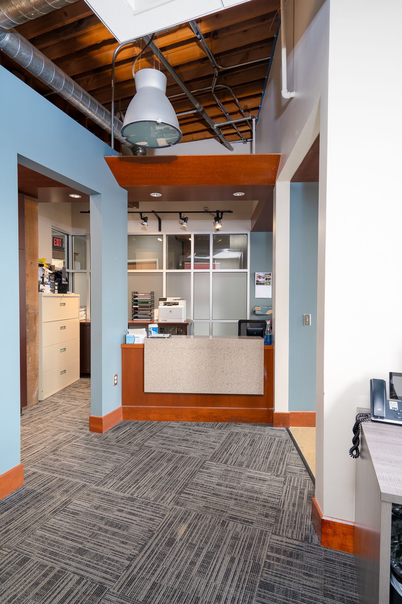 Reception area with front desk, patterned carpet, and blue walls.