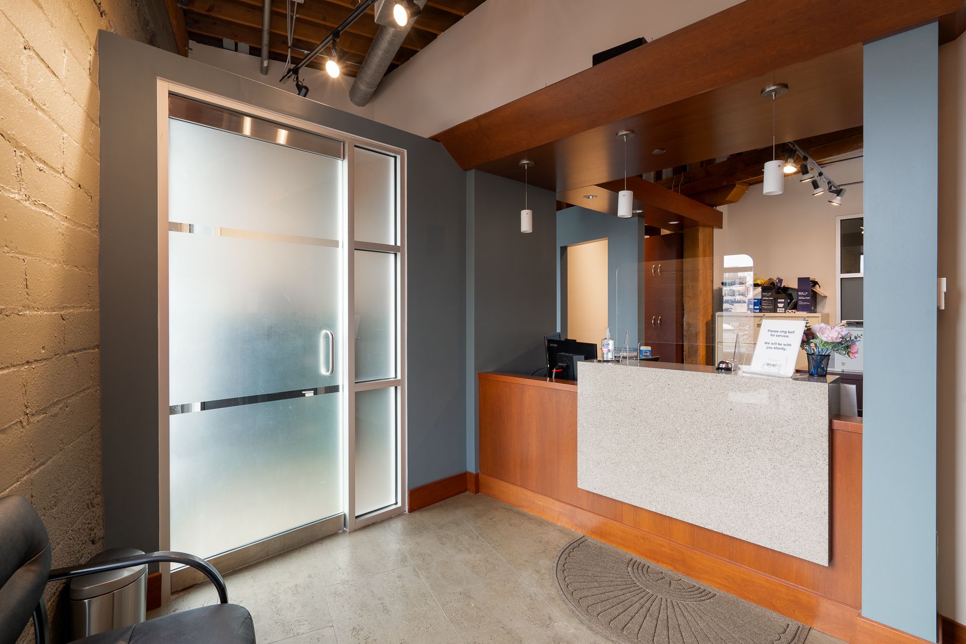 Reception area with frosted glass door, reception desk, and waiting area.