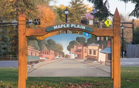 Maple Plain sign with painted town scene.