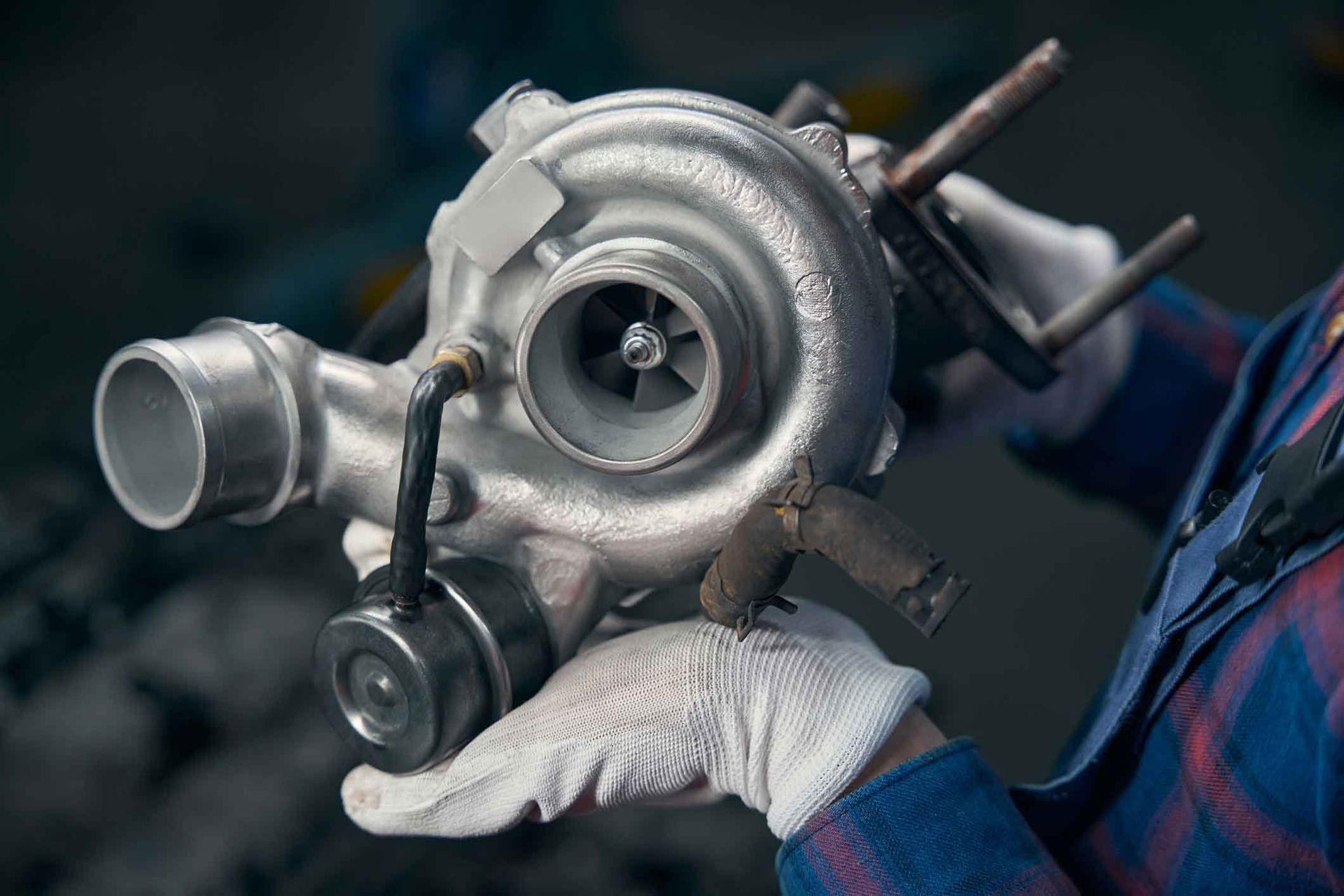 A person is holding a turbocharger in their hands.