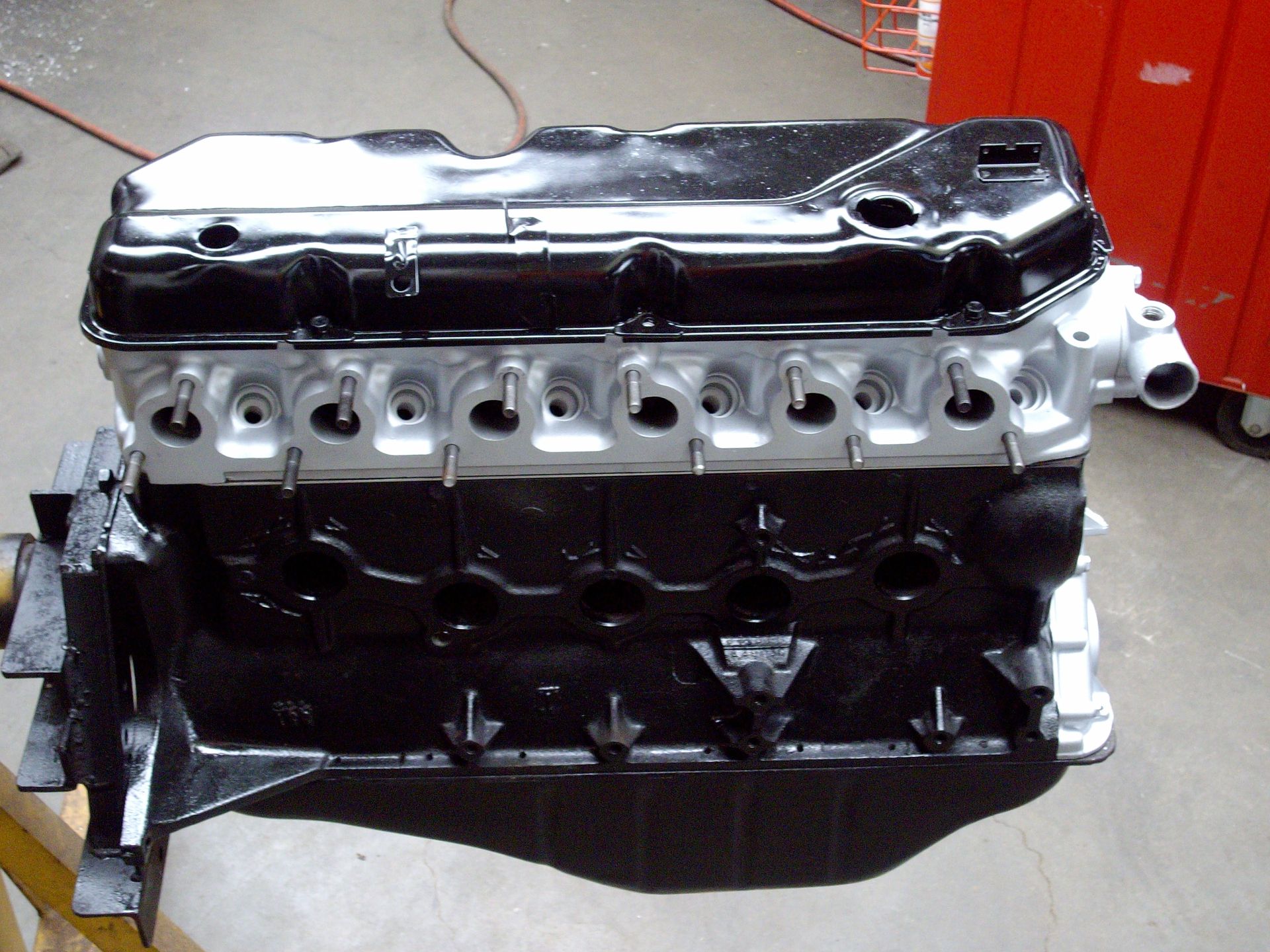 A black and silver engine is sitting on a wooden stand