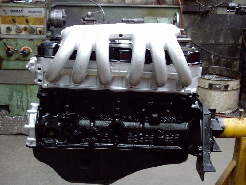 A black and white engine is sitting on a yellow stand