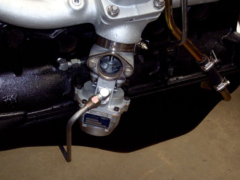 A close up of an engine with a hose attached to it