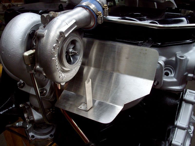 A turbocharger is sitting on top of a car engine