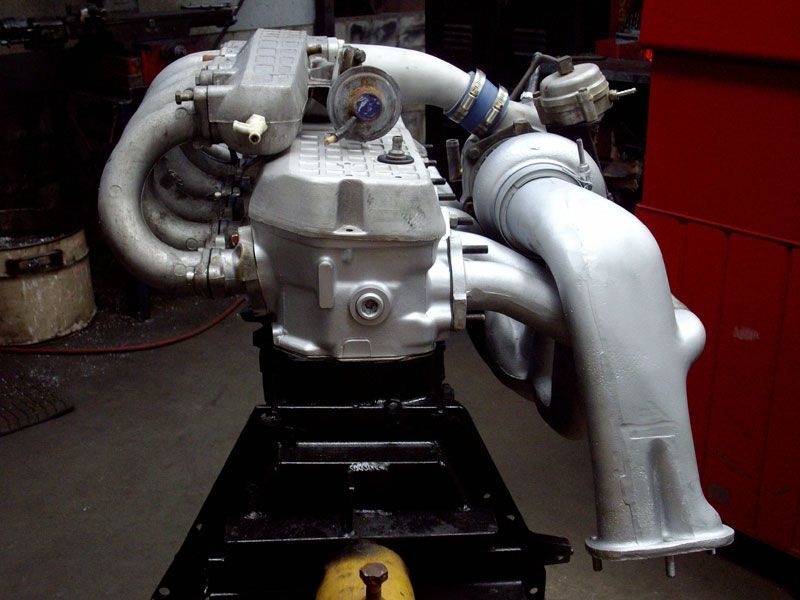 A large engine is sitting on a table in a garage