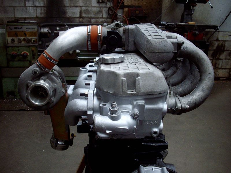 A close up of a turbocharged engine in a garage
