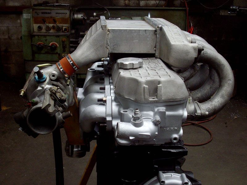 A car engine is sitting on a stand in a dark room
