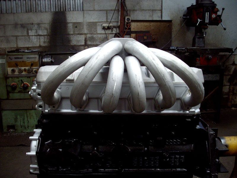 A car engine with a bunch of pipes attached to it