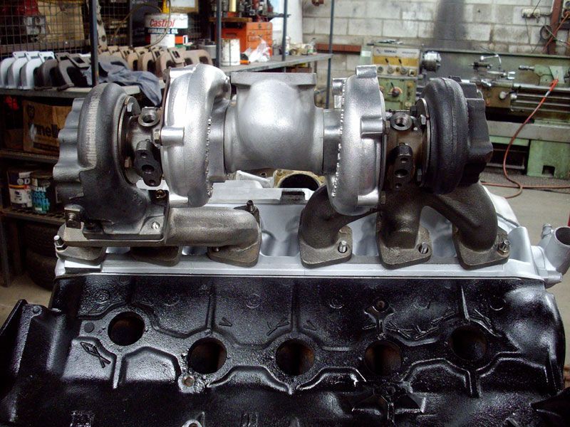 Two turbochargers are sitting on top of a black engine