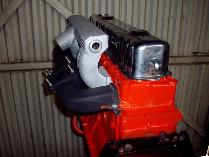 A red engine is sitting in front of a wall