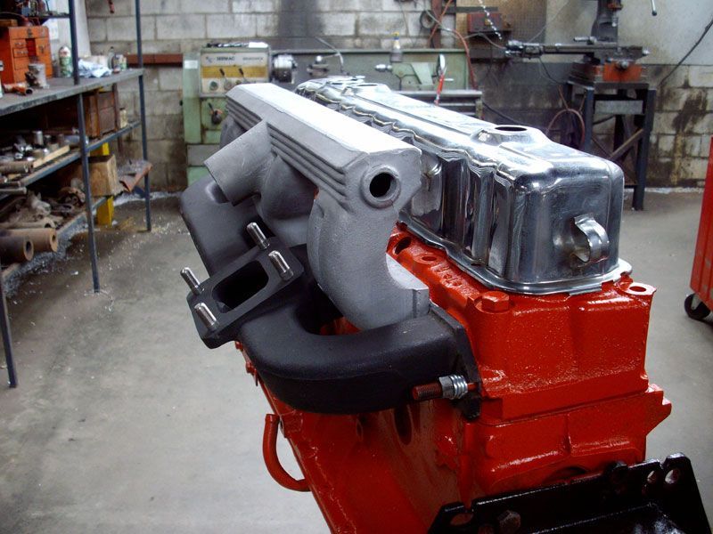 A red engine is sitting on a table in a garage