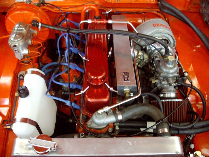 A close up of the engine of an orange car