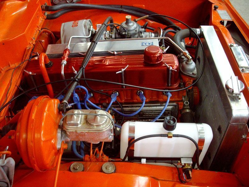 An orange car with a red engine and a white radiator