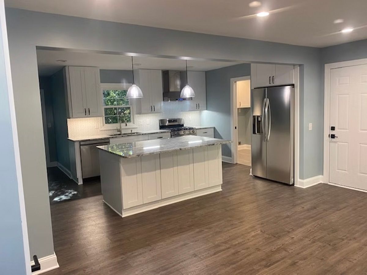A kitchen with stainless steel appliances and a large island in the middle of the room.