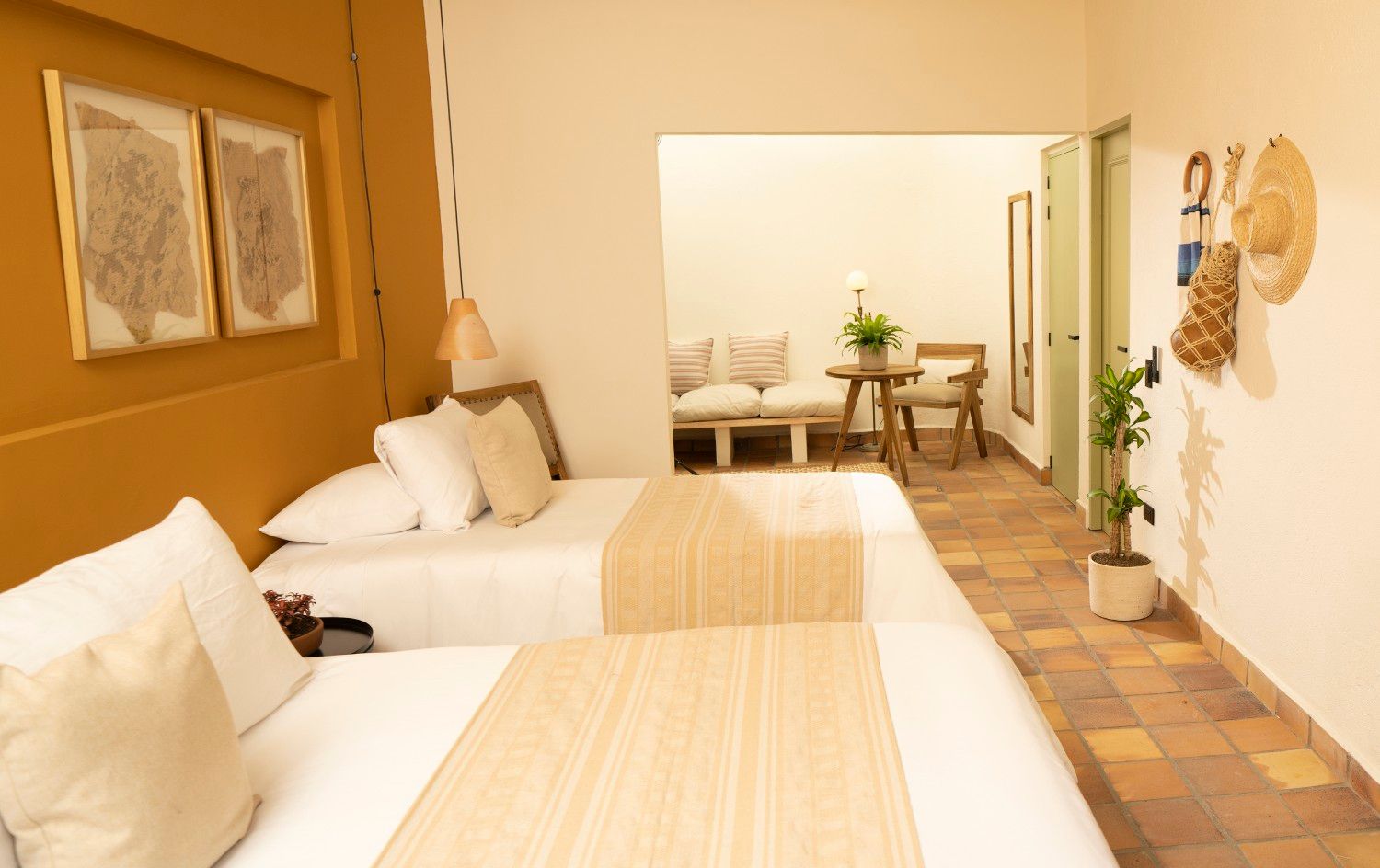 A hotel room with two beds and a couch.