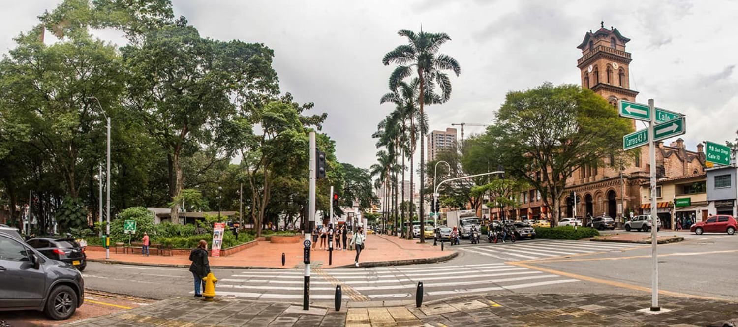 A panoramic view of a city street with a clock tower in the background.