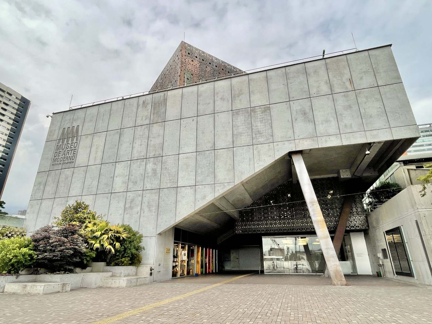 A large concrete building with a pyramid shaped roof.