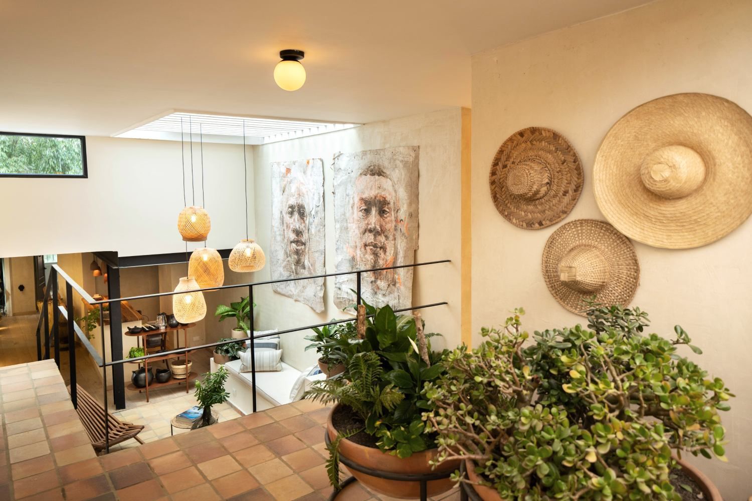 A room with straw hats hanging on the wall and a potted plant.