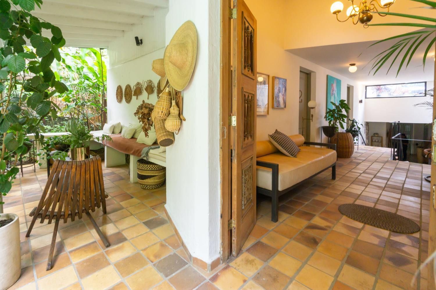 A living room with a couch , chairs , and a tiled floor.