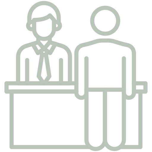 A line drawing of two people sitting at a desk.