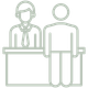 A line drawing of two people sitting at a desk.