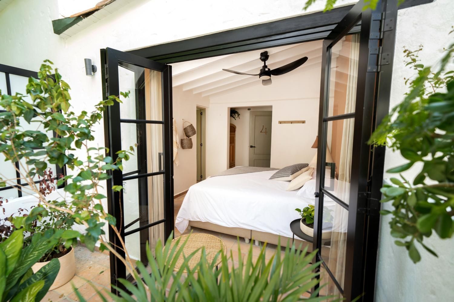 A bedroom with a bed and a ceiling fan.