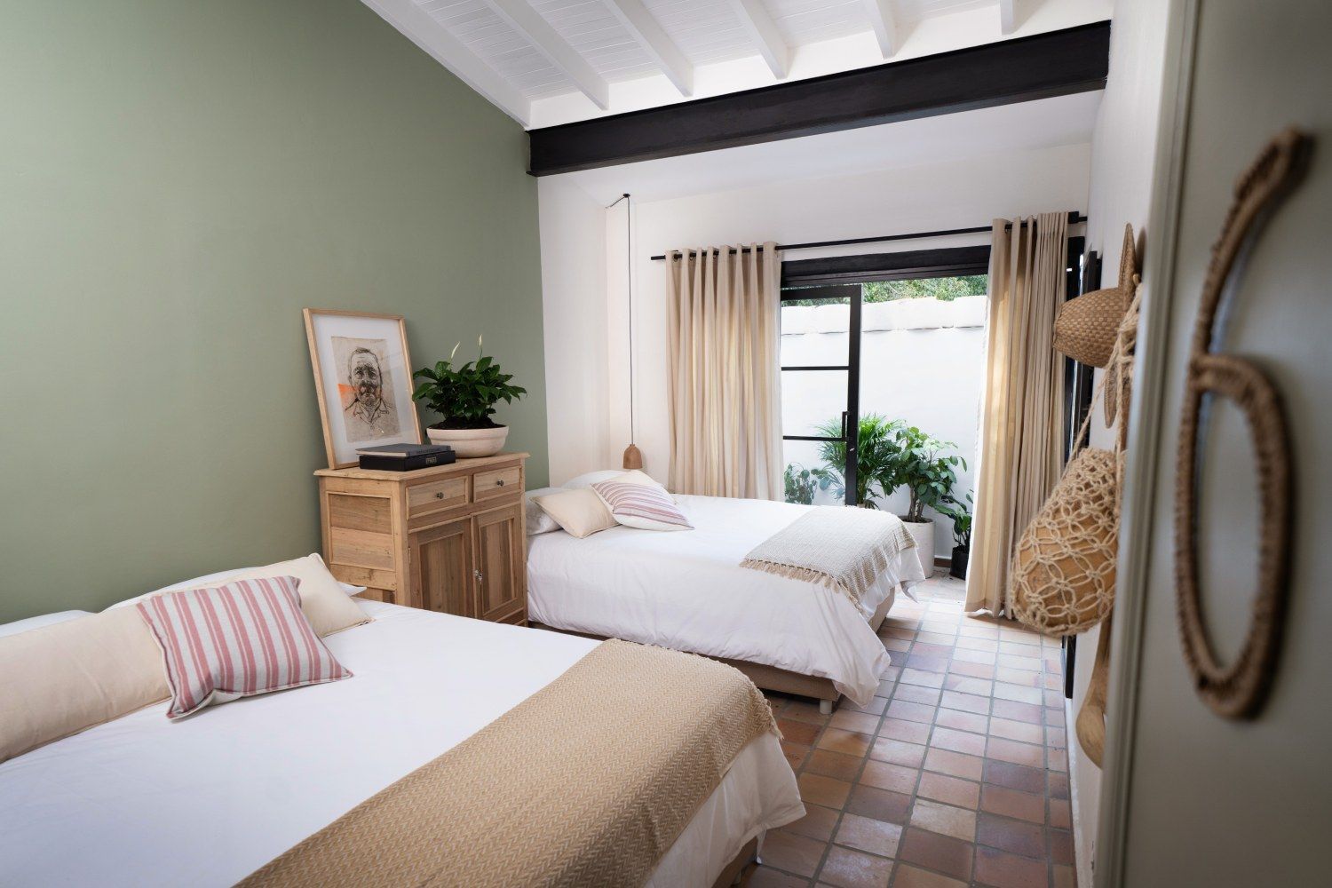 A bedroom with two beds and a sliding glass door.