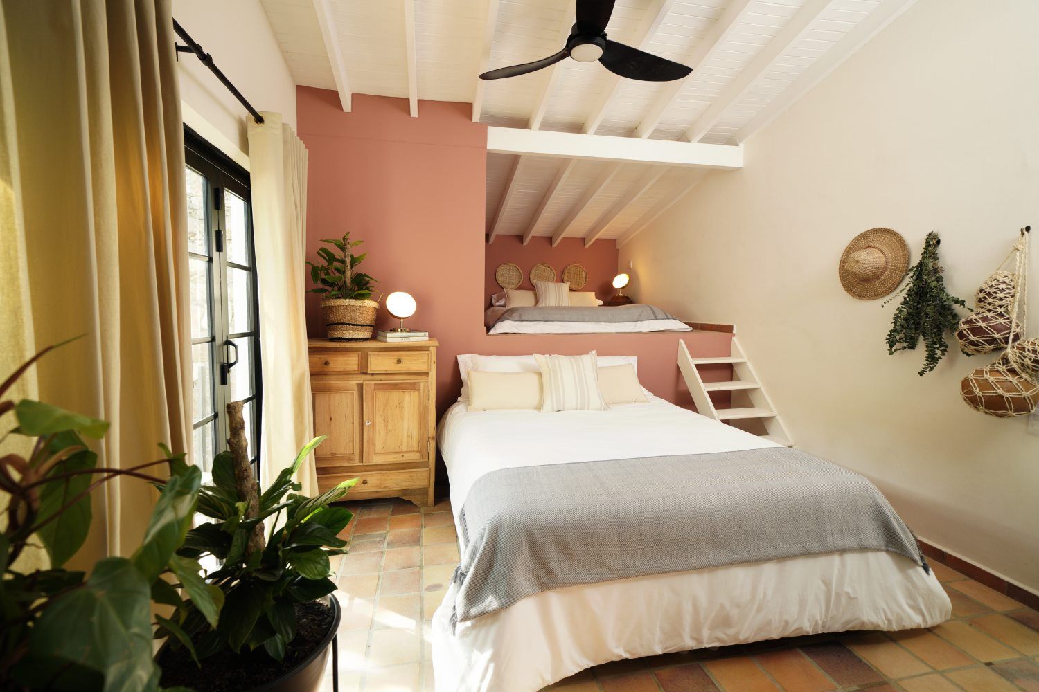 A bedroom with a bed and a ceiling fan