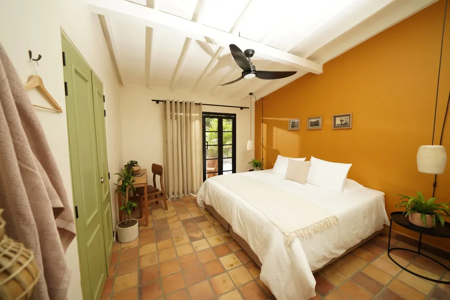 A bedroom with a large bed and a green door.