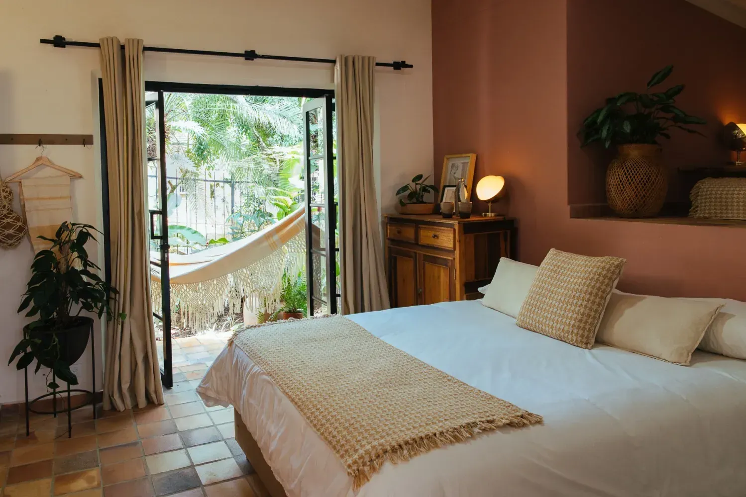 A bedroom with a king size bed and a hammock.