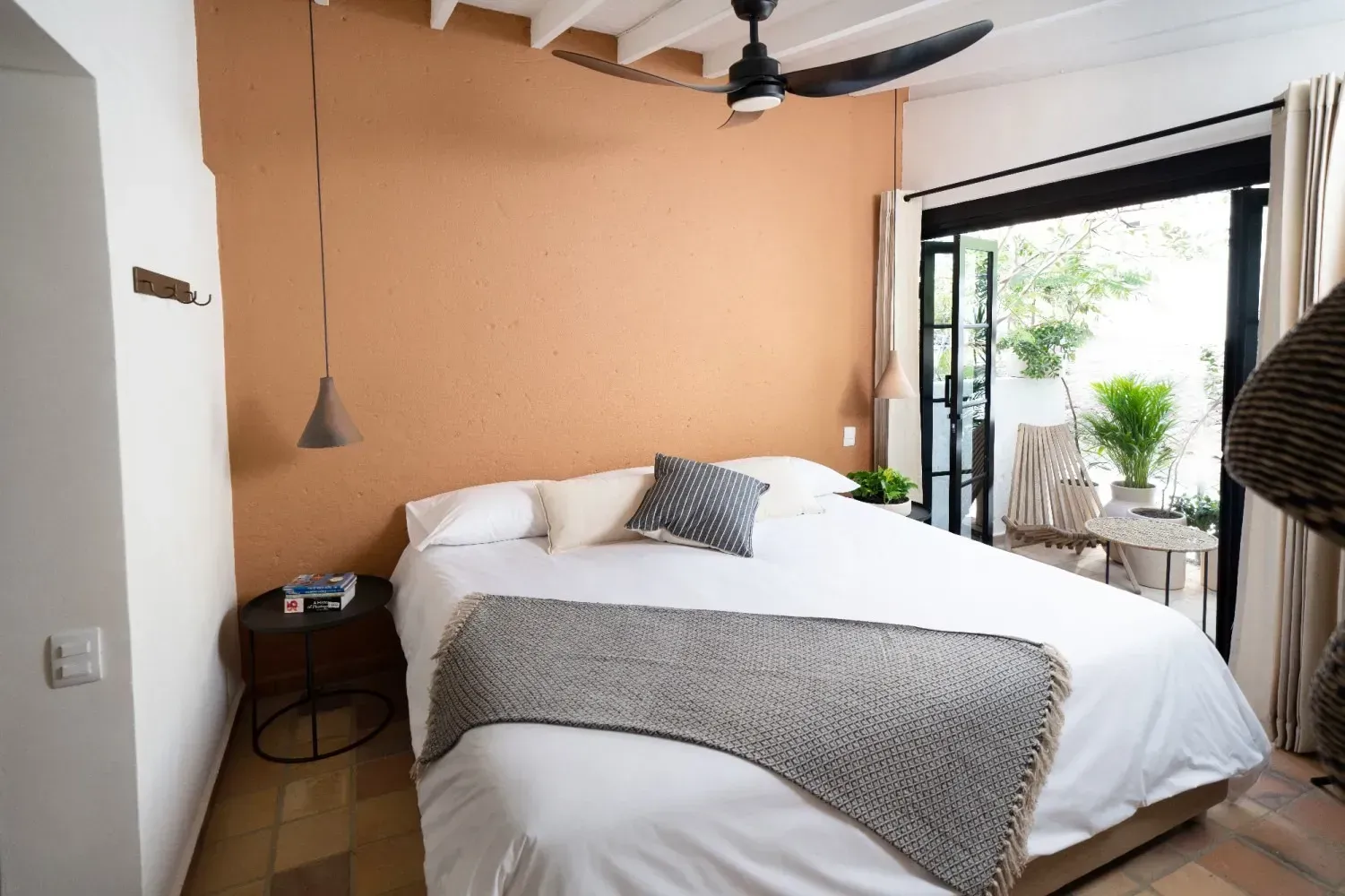 A bedroom with a large bed and a ceiling fan.