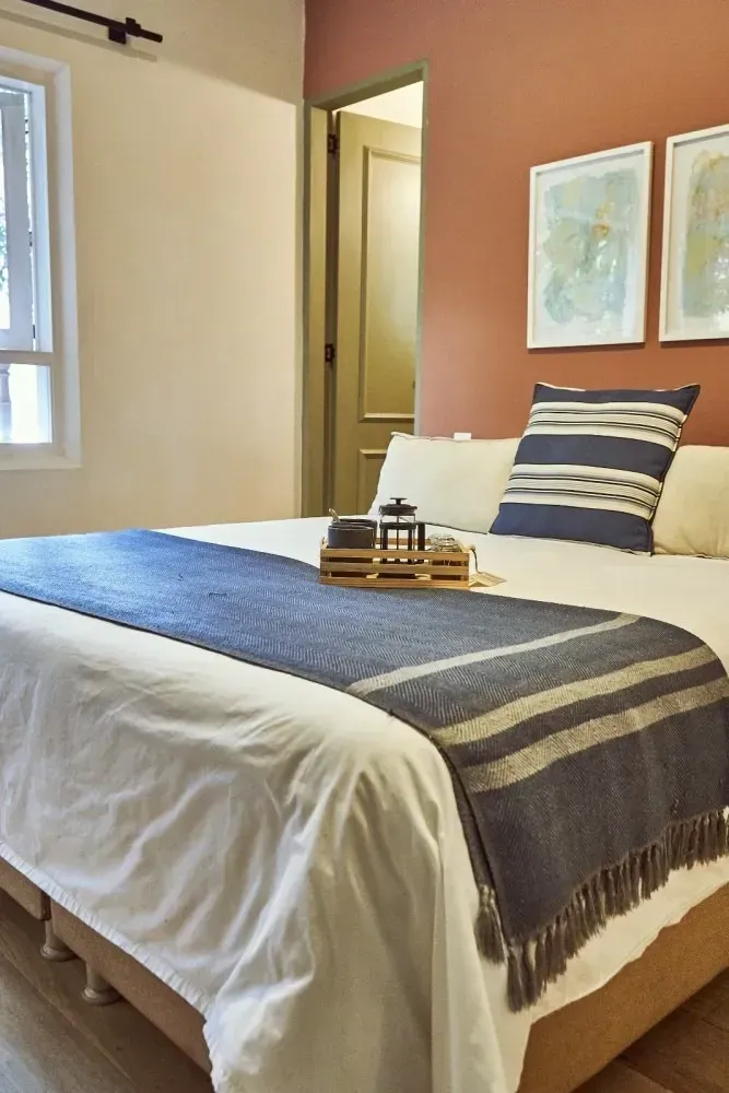 A bedroom with a bed , pillows , and a window.