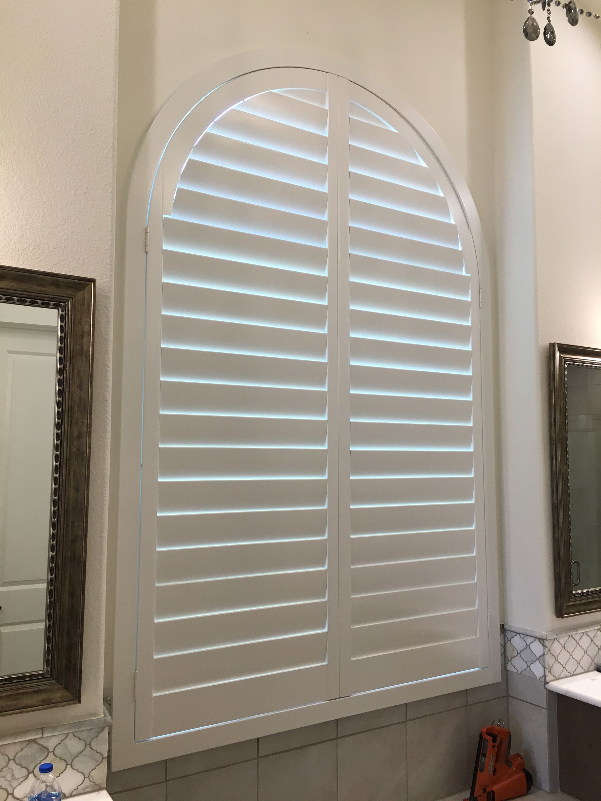 Arched window bathroom plantation blinds in Round Rock home for privacy and light control